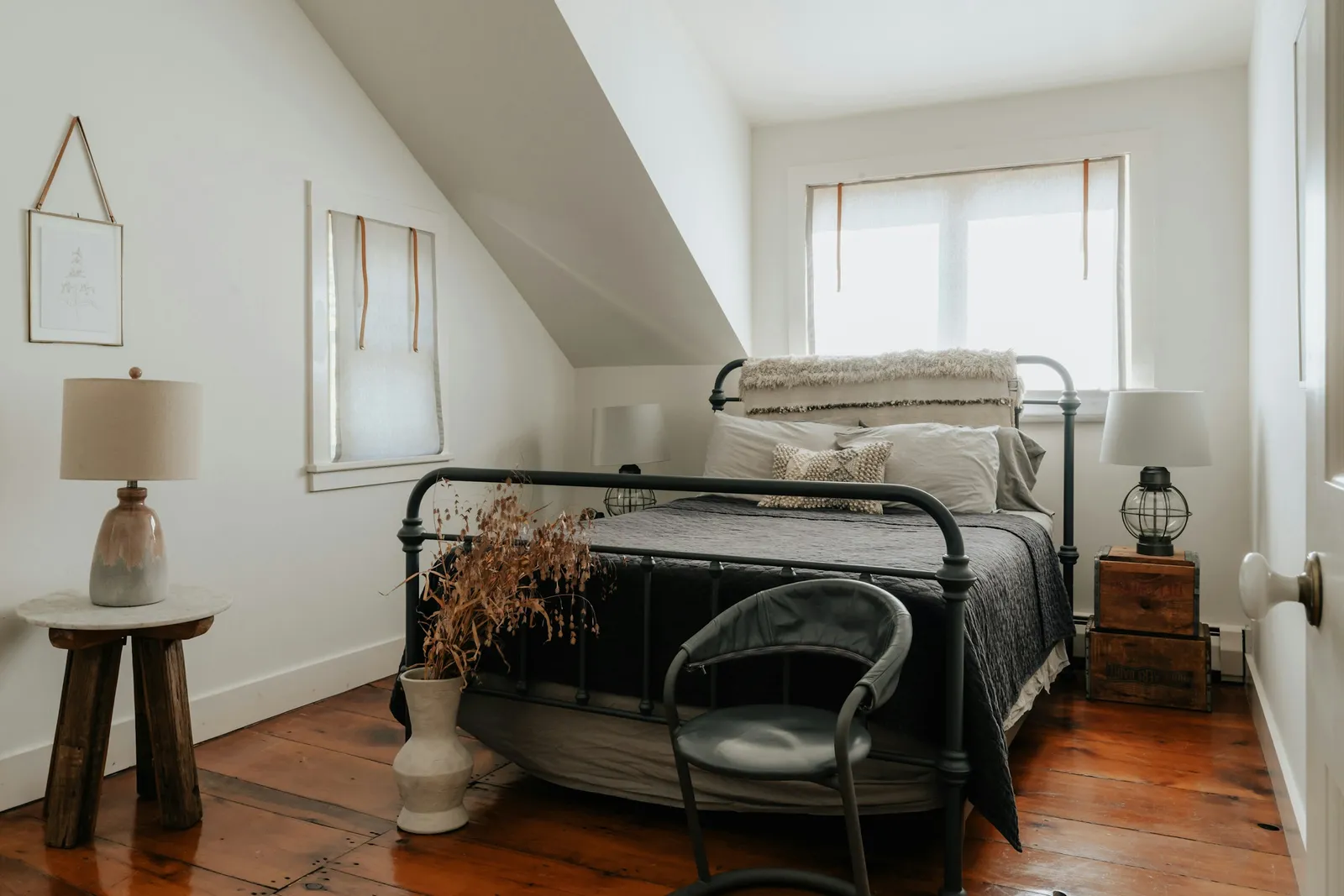 Iron bed under a sloping ceiling in a bright attic room
